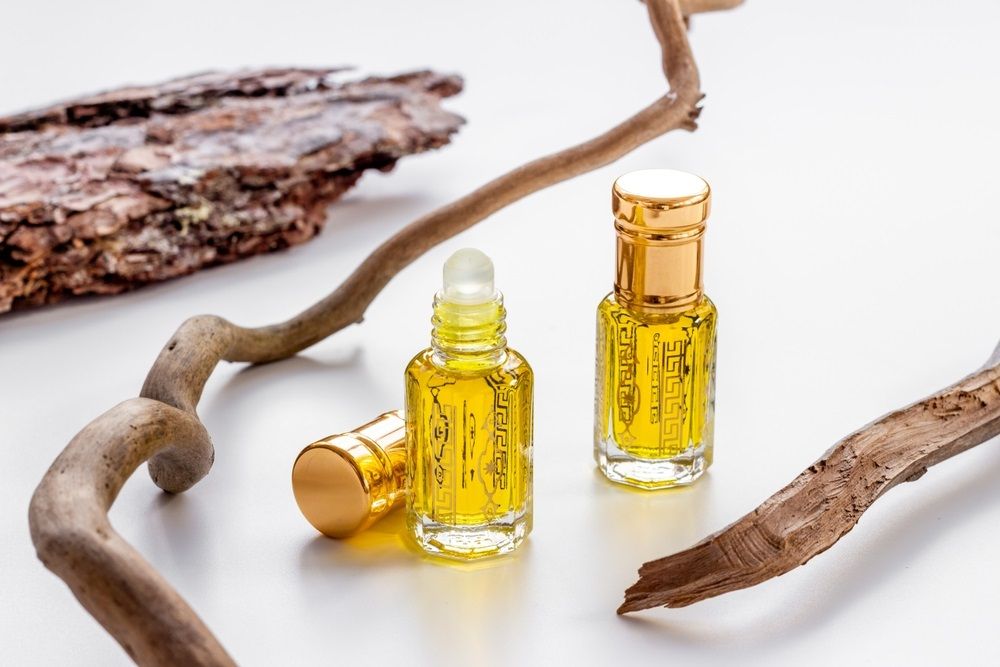 دوتا عطر روغنی در کنار چوبها
